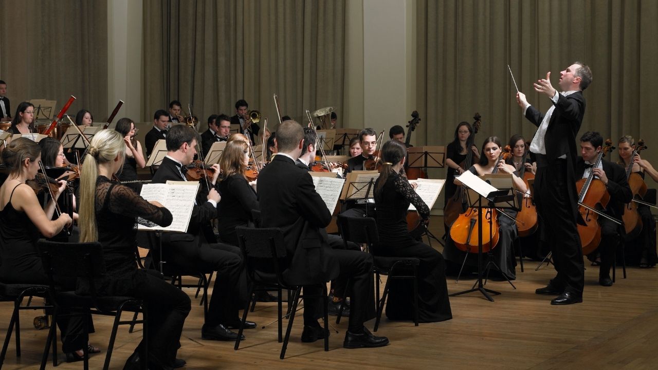 An orchestra playing live on stage.