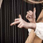 Hands,Playing,Wooden,Harp,On,Black,Background